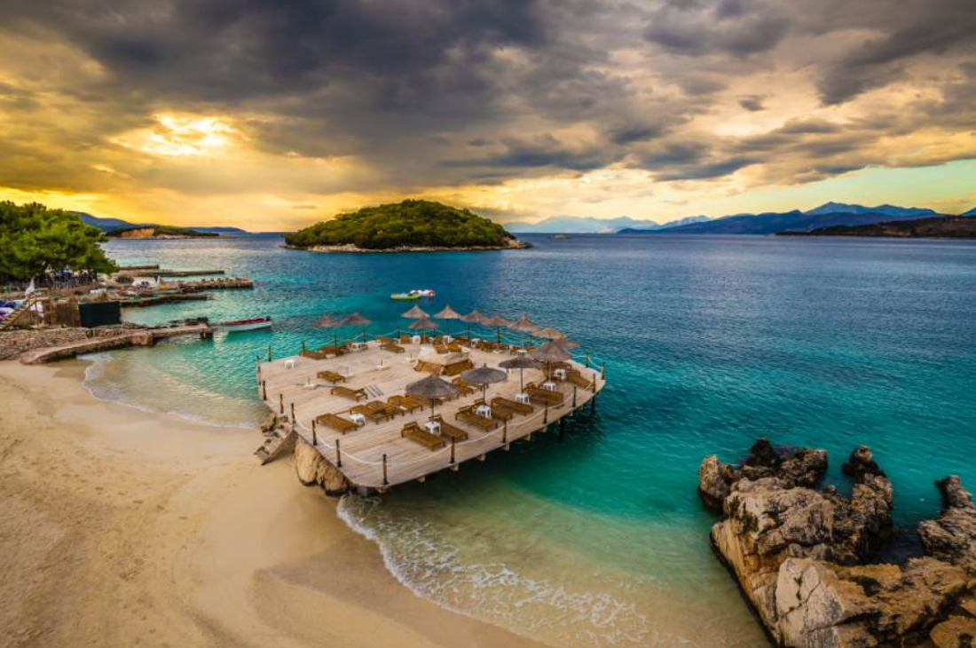 Albanian island beach and turquoise sea at sunset